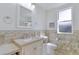 Bathroom featuring elegant tiling, a spacious countertop, and a well-lit mirror at 4721 Country Manor Dr, Sarasota, FL 34233