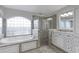 Bathroom featuring a glass block window, luxurious tub, sleek white vanity, and glass shower at 4721 Country Manor Dr, Sarasota, FL 34233