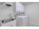 Modern laundry room with a utility sink, overhead shelving, and a washer and dryer at 4721 Country Manor Dr, Sarasota, FL 34233