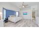 Main bedroom featuring modern flooring, ensuite bath, blue accent wall, and bay window at 4721 Country Manor Dr, Sarasota, FL 34233