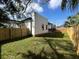 A backyard featuring a newly installed wooden fence, freshly cut grass, and access to the home at 2604 E 11Th Ave, Tampa, FL 33605