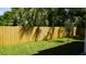 A backyard with a wood fence, trees, and the side of the house at 2604 E 11Th Ave, Tampa, FL 33605