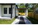 The exterior features a covered carport with a modern design and an adjacent fenced yard at 2604 E 11Th Ave, Tampa, FL 33605