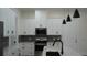 Kitchen with white cabinets, stainless appliances, granite countertops, and modern pendant lighting at 2604 E 11Th Ave, Tampa, FL 33605