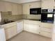 Functional kitchen with white cabinets, sleek countertops, and essential appliances at 4143 57Th N St # 502, Kenneth City, FL 33709