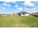 A backyard with green grass, plants, and a pristine white home in a community setting under a bright sky at 16397 Preservation Blvd, Punta Gorda, FL 33982