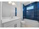 Modern bathroom featuring bold blue tile in the shower and a sleek white vanity at 16397 Preservation Blvd, Punta Gorda, FL 33982