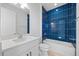 Contemporary bathroom with blue tiled walls, shower-tub combo, and stylish fixtures at 16397 Preservation Blvd, Punta Gorda, FL 33982