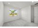 Bright bedroom with a window overlooking palm trees and a closet with sliding doors at 16397 Preservation Blvd, Punta Gorda, FL 33982