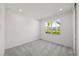 Carpeted bedroom with ample natural light streaming through the large window with backyard view at 16397 Preservation Blvd, Punta Gorda, FL 33982