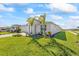 Spacious front lawn with lush landscaping and palm trees enhancing this single Gathering home's curb appeal at 16397 Preservation Blvd, Punta Gorda, FL 33982