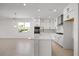 Modern kitchen with a central island, white cabinets, stainless steel appliances, and natural light at 16397 Preservation Blvd, Punta Gorda, FL 33982