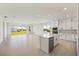Open kitchen and living area with a kitchen island, white cabinets, and modern appliances at 16397 Preservation Blvd, Punta Gorda, FL 33982