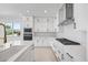 Modern white kitchen with stainless steel appliances and a large island with quartz countertops at 16397 Preservation Blvd, Punta Gorda, FL 33982