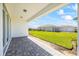 Covered patio with stone flooring, with green grass and a fenced yard at 16397 Preservation Blvd, Punta Gorda, FL 33982