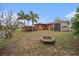 Large backyard featuring a fire pit, shed, and spacious deck at 1768 Suffolk Dr, Clearwater, FL 33756