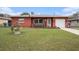 Charming single-story red brick home featuring a well-manicured lawn and inviting curb appeal at 1768 Suffolk Dr, Clearwater, FL 33756