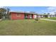 Cozy single-story home with a spacious front yard, blue outdoor chairs and green lawn at 1768 Suffolk Dr, Clearwater, FL 33756