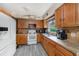 Bright kitchen featuring tile floors, wood cabinets, white appliances, and backsplash at 1768 Suffolk Dr, Clearwater, FL 33756