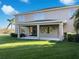 Backyard featuring a covered patio, green lawn, and views of the pond at 6113 Shadowlake Dr, Apollo Beach, FL 33572