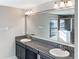 Bathroom with double sink vanity, granite countertop, framed mirror, and shower with glass door at 6113 Shadowlake Dr, Apollo Beach, FL 33572