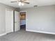 Neutral bedroom featuring gray walls, carpet flooring, and a double closet for storage at 6113 Shadowlake Dr, Apollo Beach, FL 33572