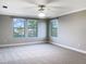Spacious, carpeted bedroom featuring three windows and neutral wall colors at 6113 Shadowlake Dr, Apollo Beach, FL 33572