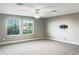 Bright bonus room with carpet flooring, two windows with blinds, and a ceiling fan at 6113 Shadowlake Dr, Apollo Beach, FL 33572