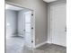 Modern entryway with white paneled door, stylish flooring, and view into another room at 6113 Shadowlake Dr, Apollo Beach, FL 33572