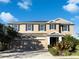 Charming two-story home with three-car garage and well-manicured landscaping on a sunny day at 6113 Shadowlake Dr, Apollo Beach, FL 33572