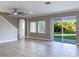 Spacious living room with tile flooring, ceiling fan, and sliding glass doors to the backyard at 6113 Shadowlake Dr, Apollo Beach, FL 33572