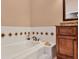 Bathroom with a step-up tub, white tile with decorative accents, and elegant vanity details at 5011 88Th E St, Bradenton, FL 34211