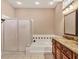 Bathroom featuring granite counters, double sinks, white tiled floor, and a glass-enclosed shower at 5011 88Th E St, Bradenton, FL 34211