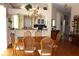 Elegant dining room with wooden table and chairs open to kitchen with a stunning chandelier at 5011 88Th E St, Bradenton, FL 34211