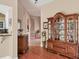 Hallway with hardwood floors and a wooden display case with a view to more rooms at 5011 88Th E St, Bradenton, FL 34211