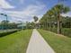 Scenic pathway leads to well-maintained tennis courts amid lush greenery and mature trees at 5011 88Th E St, Bradenton, FL 34211