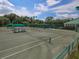 Wide shot of an outdoor tennis court with net, surrounding greenery and blue sky at 5011 88Th E St, Bradenton, FL 34211