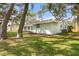 Landscaped backyard featuring lush green grass and mature trees providing ample shade at 530 Foxglove Rd, Venice, FL 34293