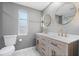 Bathroom features a double vanity with framed mirrors, updated lighting and fixtures, and a toilet at 530 Foxglove Rd, Venice, FL 34293