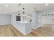 Open-concept kitchen featuring bar seating, modern light fixtures, and stainless steel appliances at 530 Foxglove Rd, Venice, FL 34293