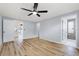 The main bedroom has wood floors, a ceiling fan, and doors leading to a bathroom and sunroom at 530 Foxglove Rd, Venice, FL 34293
