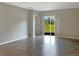 Well-lit living room featuring tile floors, neutral paint, and sliding glass doors leading to the backyard at 14853 Crescent Rock Dr, Wimauma, FL 33598