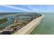 Breathtaking aerial view showcasing the sandy shoreline, turquoise waters, and city skyline of Redington Shores on a sunny day at 318 182Nd E Ave, Redington Shores, FL 33708