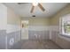 The unfurnished bedroom features neutral walls, carpeted floors, a ceiling fan, and a window offering natural light at 318 182Nd E Ave, Redington Shores, FL 33708