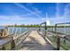 Exterior shot of weathered wooden dock with boat lift, offering picturesque waterfront views on a bright, sunny day at 318 182Nd E Ave, Redington Shores, FL 33708