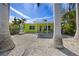 Charming single-story home boasts a vibrant lime-green exterior, rock garden, and a welcoming front porch with views of the sunny sky at 318 182Nd E Ave, Redington Shores, FL 33708