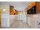 Kitchen awaiting remodel, features wooden cabinets, neutral tile flooring, and ample space with a doorway to the back at 318 182Nd E Ave, Redington Shores, FL 33708