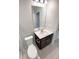Modern bathroom features a sleek vanity with a white countertop, a large mirror, and a white toilet at 36880 Precita Ter, Zephyrhills, FL 33542