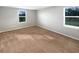 Neutral bedroom featuring carpeted floors and two windows at 36880 Precita Ter, Zephyrhills, FL 33542