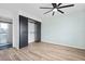 Bedroom featuring wood-look floors, neutral walls, ceiling fan, and barn door closet next to renovated bathroom at 511 Sharon Cir, Port Charlotte, FL 33952